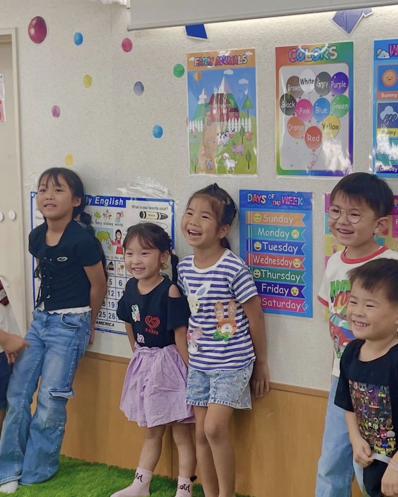 教室の壁の前で笑う子どもたち